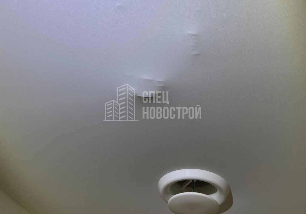 видны очертания гофры вентиляционного канала санузла под полотном натяжного потолка